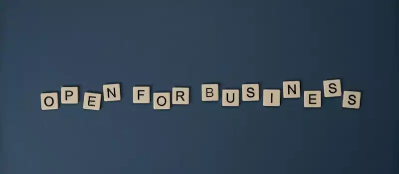 Creative flat lay with 'Open for Business' text on dark blue surface. Conceptual design ideal for business themes.