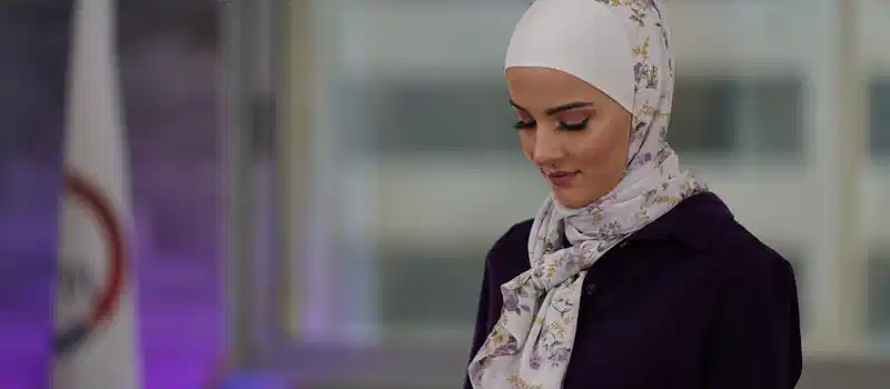 Portrait of a woman in hijab using a smartphone indoors, Amman, Jordan.