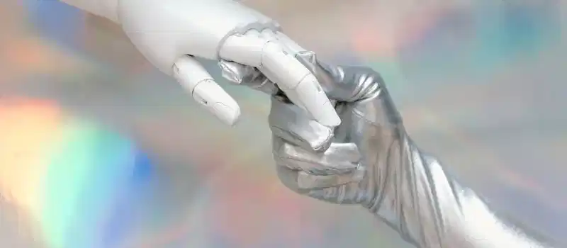 Close-up of a robot hand and silver-gloved hand touching, symbolizing human-robot connection.