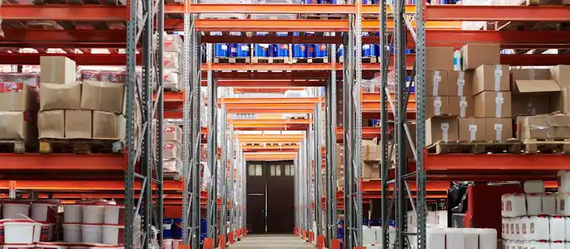 Wide angle view of a warehouse with stocked shelves and boxes.