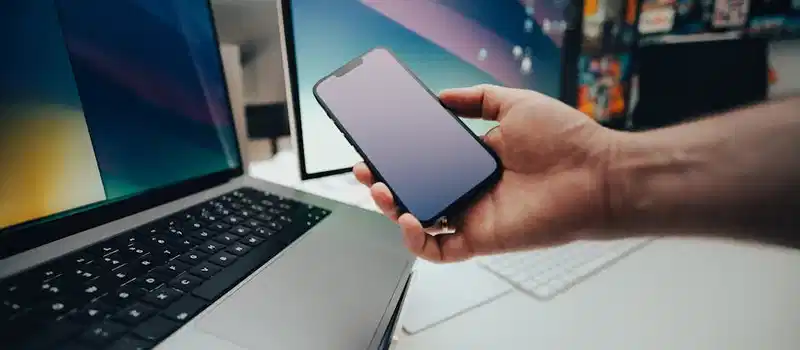 A contemporary workspace with a smartphone and laptop, showcasing modern technology in use.