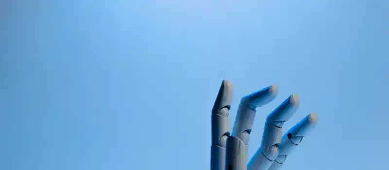 Robotic hand with articulated fingers reaching towards the sky on a blue background.