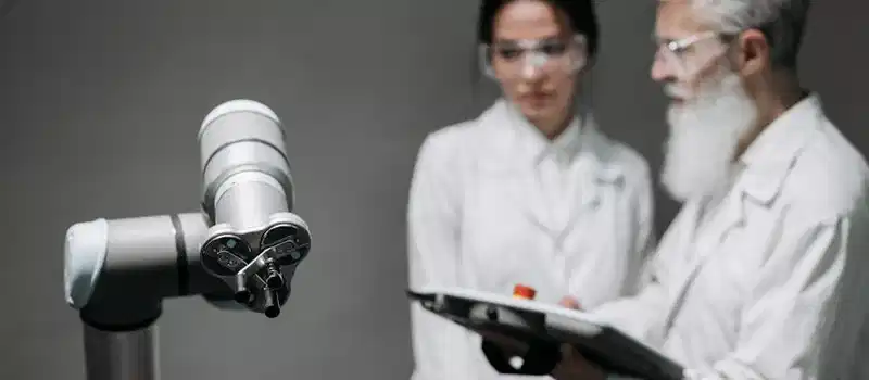 Researchers in lab coats analyze robotic equipment for technological advancement.