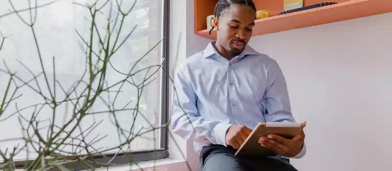 Confident businessman using a tablet in a modern office setting, focusing on work.