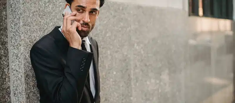 Businessman in a suit talking on a phone outdoors, portrait of a confident businessman.
