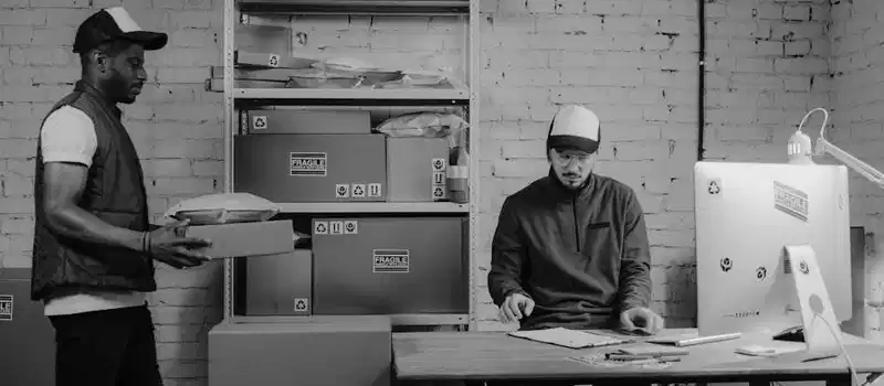 Courier workers organizing packages at an office, ensuring efficient logistics and delivery services.