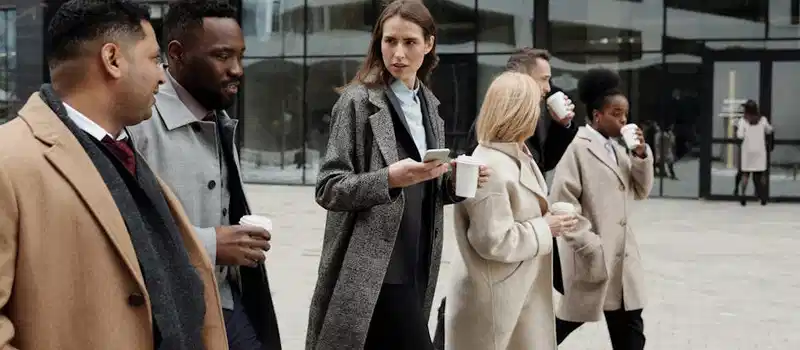 A group of diverse business professionals enjoying a coffee break outdoors in the city.