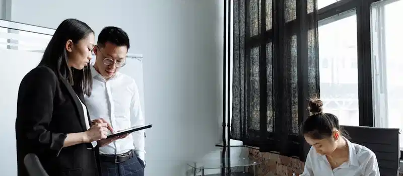 Professionals collaborating in a modern office environment, focusing on planning and teamwork.