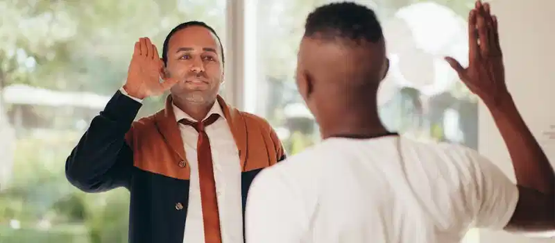 Two diverse business colleagues exchanging a high five in an office setting.