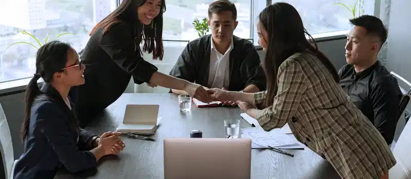 A diverse group of professionals collaborating in an office meeting, fostering teamwork and innovation.