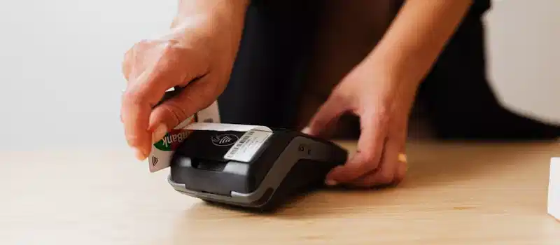 A person makes a cashless payment using a credit card on a payment terminal.