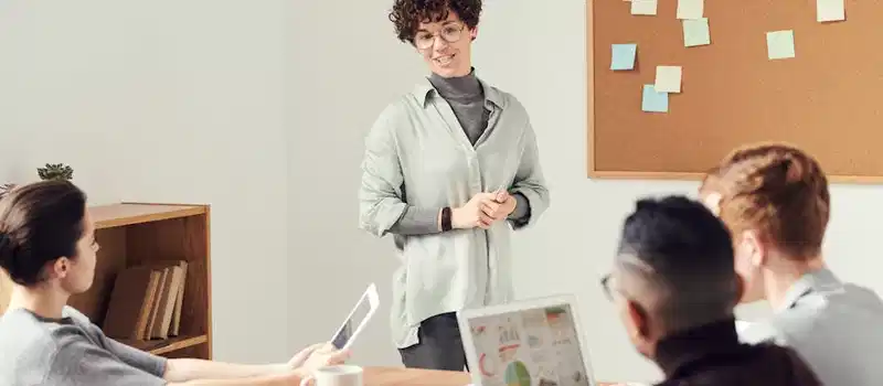 Diverse team discussing ideas during an office meeting with charts displayed on laptops.