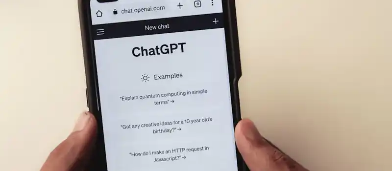 Close-up of hands holding a smartphone displaying the ChatGPT application interface on the screen.