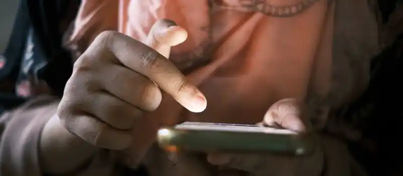 Close-up of hands using a smartphone indoors, highlighting touch technology.
