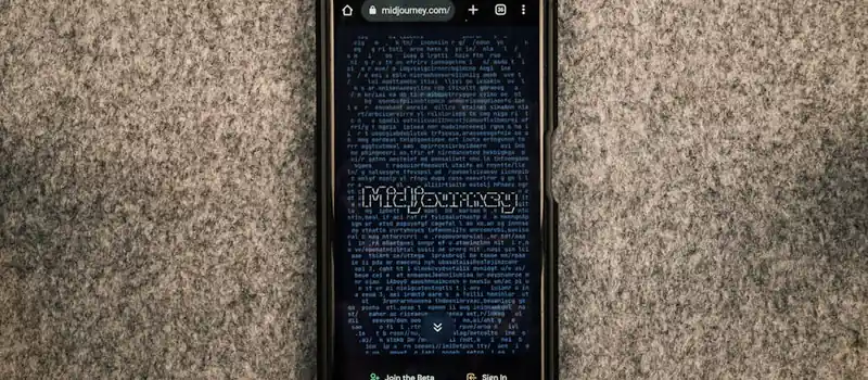 A smartphone showing the Midjourney website on its screen against a gray textured surface.