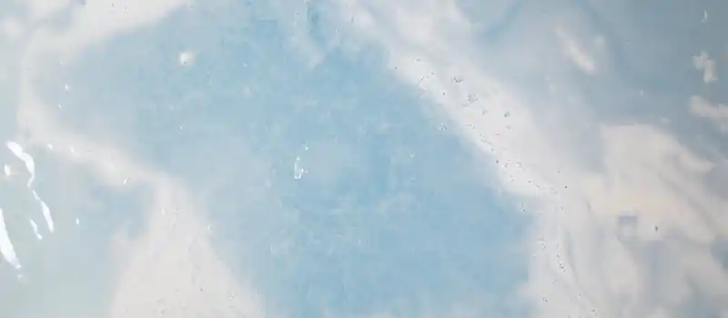 A calming top view of blue and white swirling water with bubbles and foam.