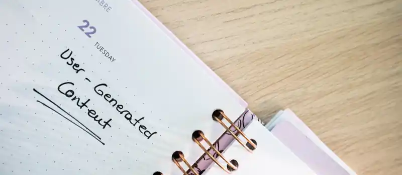 Open planner showing a date with handwritten notes on a wooden desk.