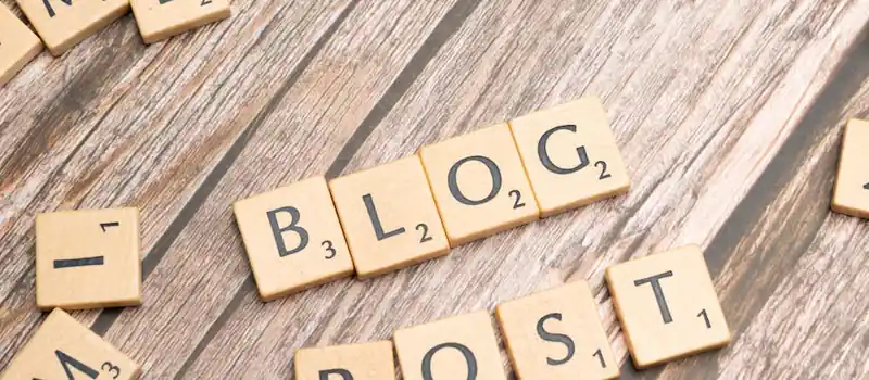 Wooden letter tiles spelling 'Blog Post' on a wooden background, ideal for online media concepts.