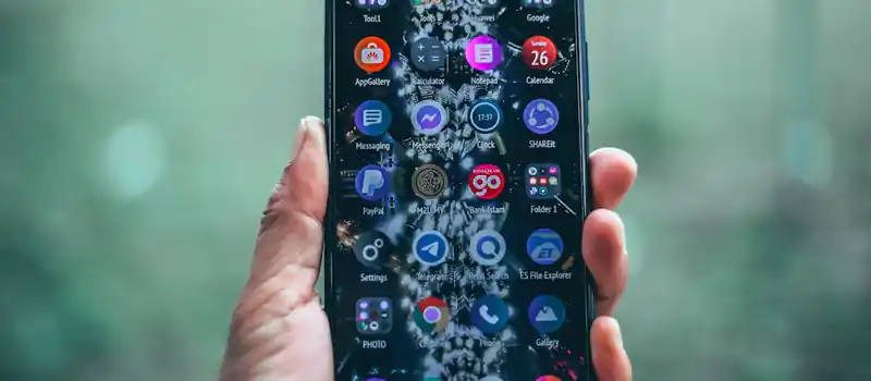 Smartphone with various apps in hand, focus on technology and connectivity.