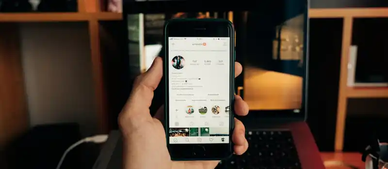 Close-up of a hand holding a smartphone with Instagram open, showcasing technology in use.