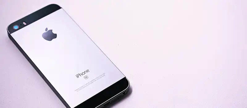 A sleek and modern smartphone placed on a minimalistic light surface, showcasing its design.