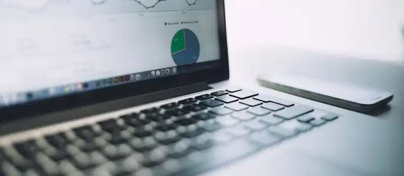A laptop showing an analytics dashboard with charts and graphs, symbolizing modern data analysis tools.