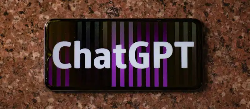 Smartphone displaying ChatGPT on an abstract colorful background, top view.