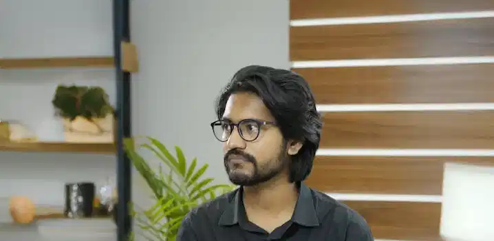Portrait of a young professional in a modern office with wooden panel decor.