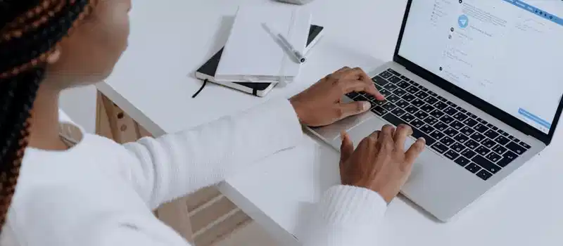 A woman engaging with social media on a laptop in a modern workspace.