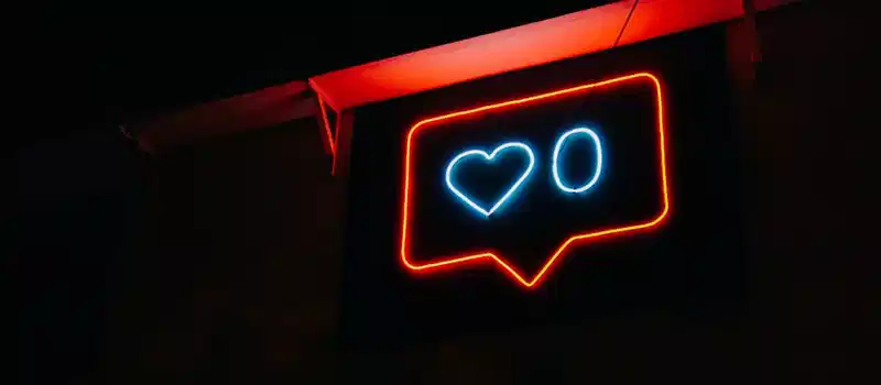 Bright neon heart icon with zero likes, symbolizing social media engagement.