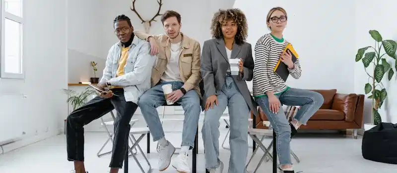 A multicultural group of young professionals in a modern office setting, showcasing teamwork and creativity.