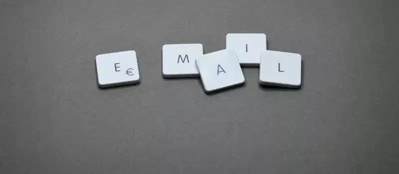 Close-up of the word 'email' formed with letter tiles on a gray surface.