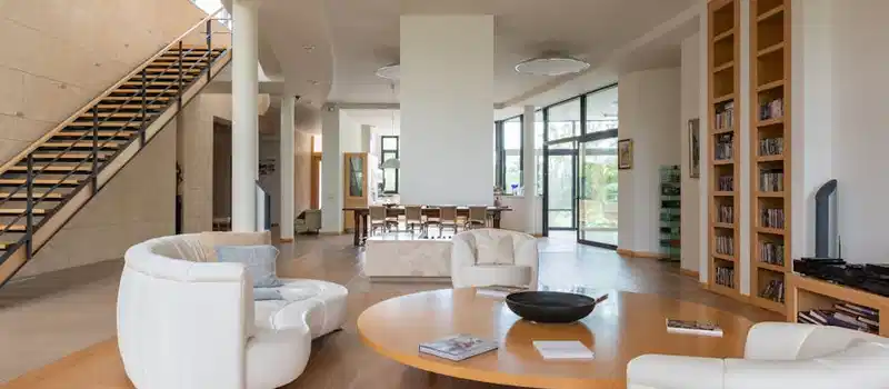 Large apartment with modern interior and soft armchair with white sofa near stairs