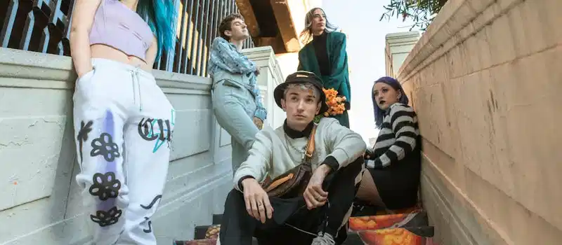 Group of young adults showcasing diverse street fashion on urban stairs.