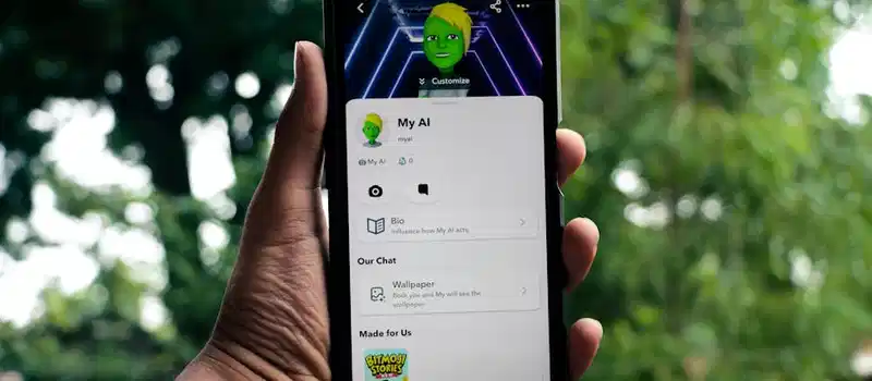 A person holds a smartphone displaying an AI application in a green outdoor setting.