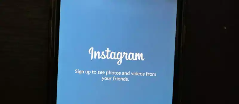 Close-up of a smartphone displaying the Instagram app welcome screen, inviting users to sign up.