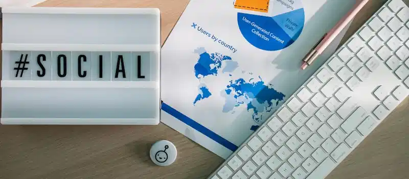 Top view of a desk with social media hashtag, keyboard, and analytics chart in modern design.