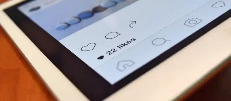 Photo of a tablet displaying a social media app interface with 22 likes, highlighting digital interaction.