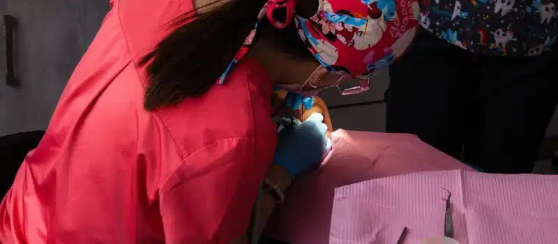 A dentist in vibrant scrubs focuses intently on a dental procedure.