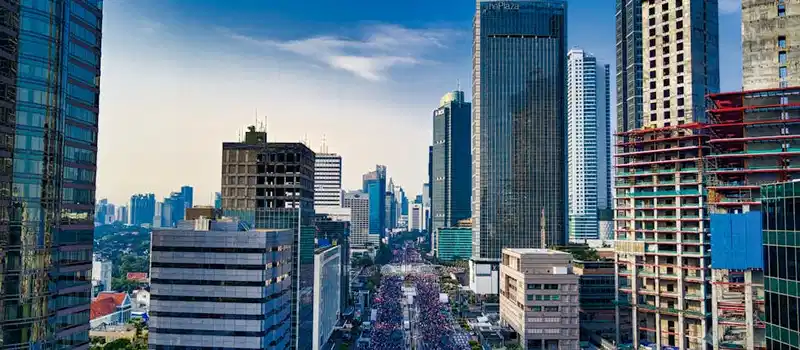 Stunning aerial view of Jakarta's modern skyline with bustling streets below.