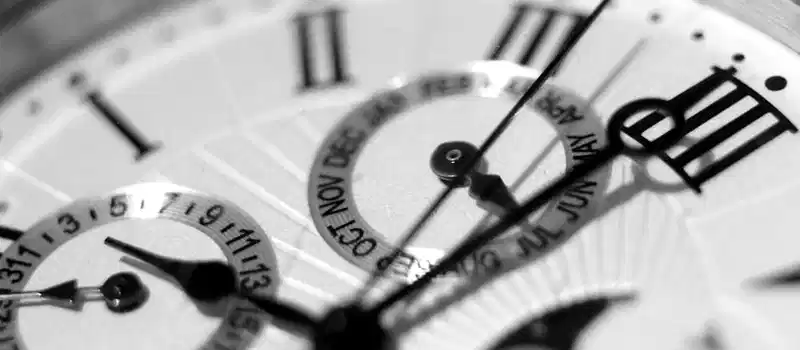 Detailed black and white shot of an elegant watch face showcasing timekeeping elements.
