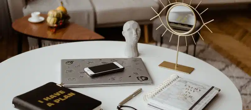 Stylish home office setup with planner, tech devices, and unique decor for productivity.