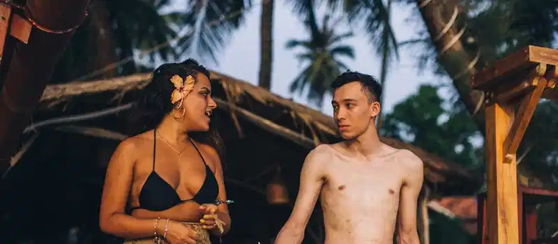 A lively young couple enjoying a tropical retreat at a beachside location.