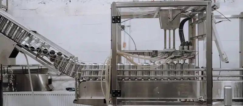 Automated beverage can packaging in a modern factory setting.