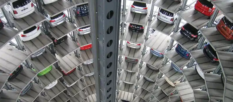 A vertical view of a spiral multi-storey car park filled with vehicles.