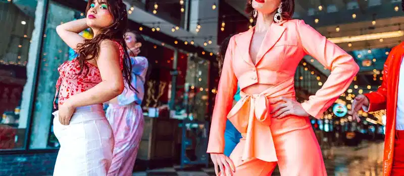 Stylish individuals posing with confidence in a chic, indoor setting.