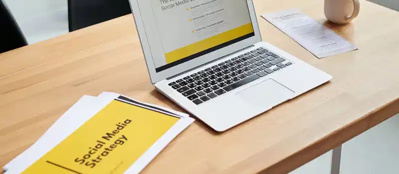 Close-up of a laptop showing a social media marketing strategy in an office setting.