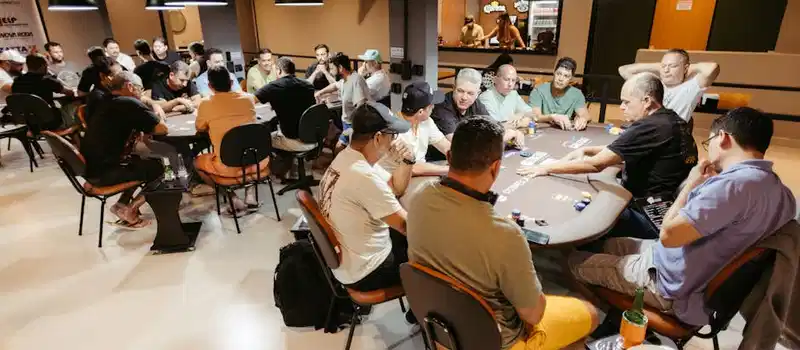 A vibrant poker game with participants intensely focused in a casino setting.