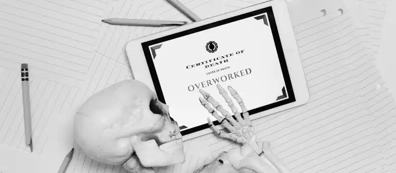 Black and white image of skeleton hand holding tablet with 'Certificate of Death' showing overworked.