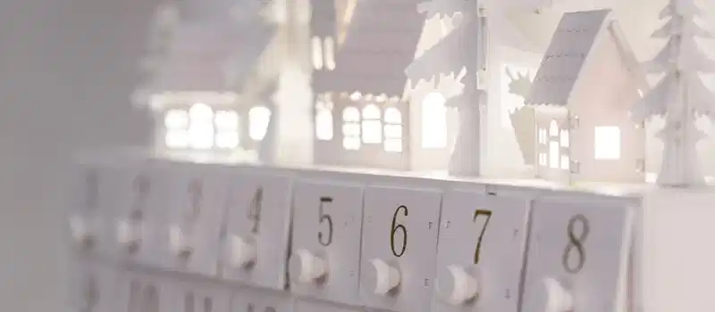 Beautiful minimalist advent calendar with illuminated houses and numbers for winter decor and festive ambiance.